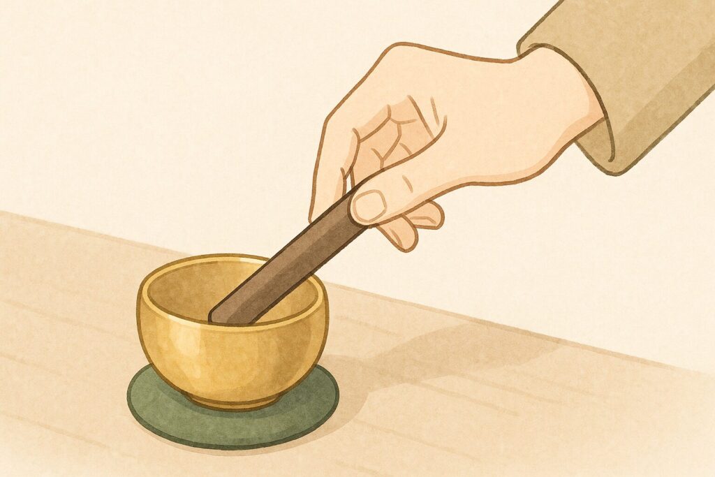 お勤めの合図として、りん棒を使いおりんを優しく鳴らす瞬間の手元をアップで描いたイラスト。浄土真宗の基本的な作法の一つ。